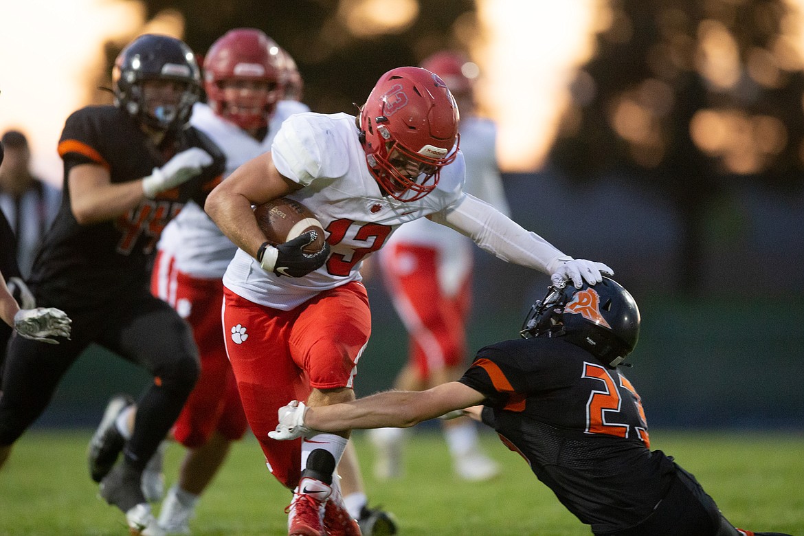 Senior running back Gerrit Cox stiff arms a Post Falls defender during the season opener on Aug. 27.