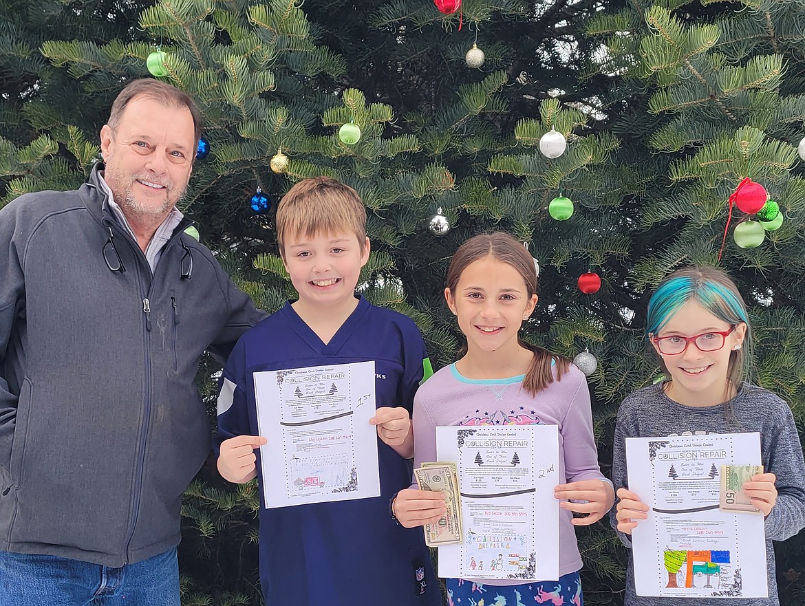 Shane Florea of North Idaho Collision Repair Center poses with the winners of the company's Christmas card. Ezekiel Cornett was named the first place winner, Reese Liermann was named the second place winner and Phoenix Lakey was named the third place winner.