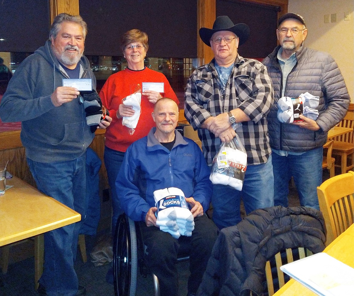 Photo courtesy Nancy Conley 
The Back Country ATV/UTV Association recently donated $1,000 to the Kootenai Humane Society, $1,000 to Shriners Hospital, 230 pairs of new socks to St Vincent de Paul for warming shelters and 105 pounds of food to the Post Falls Food Bank. Back row from left, Bret Uhlich, incoming club president, Nancy Conley, secretary, Orlan Meckle, outgoing president and Craig Brockus, outgoing vice president. Seated is  Frank Travor.