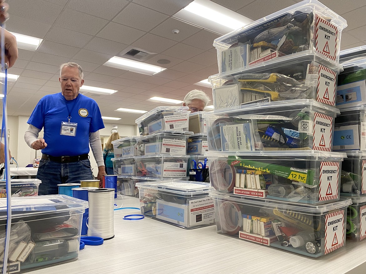 Kootenai County Office of Emergency Management volunteer Ed Stuckey stands next to a stack of emergency kits packed at the "Preparedness for a Cause" event on Wednesday. (MADISON HARDY/Press)