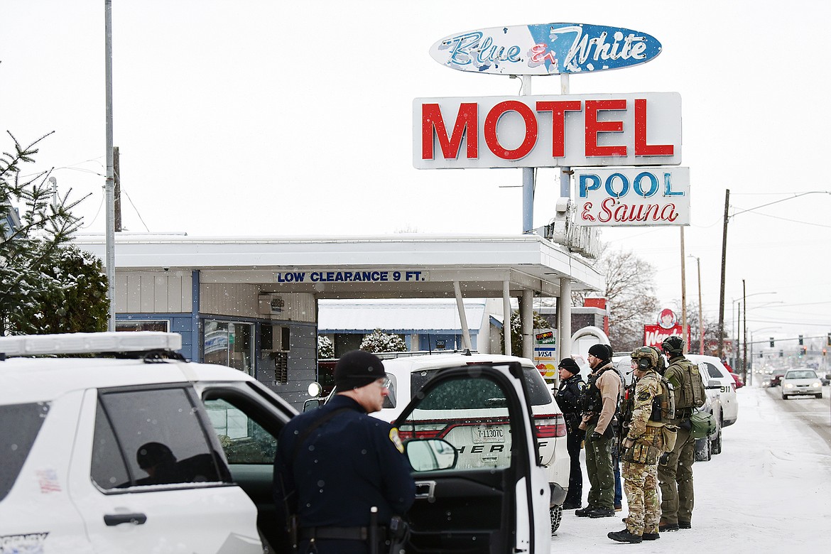 Law enforcement personnel stand at the scene of a standoff at the Blue & White Motel in Kalispell on Thursday, Dec. 16. (Casey Kreider/Daily Inter Lake)