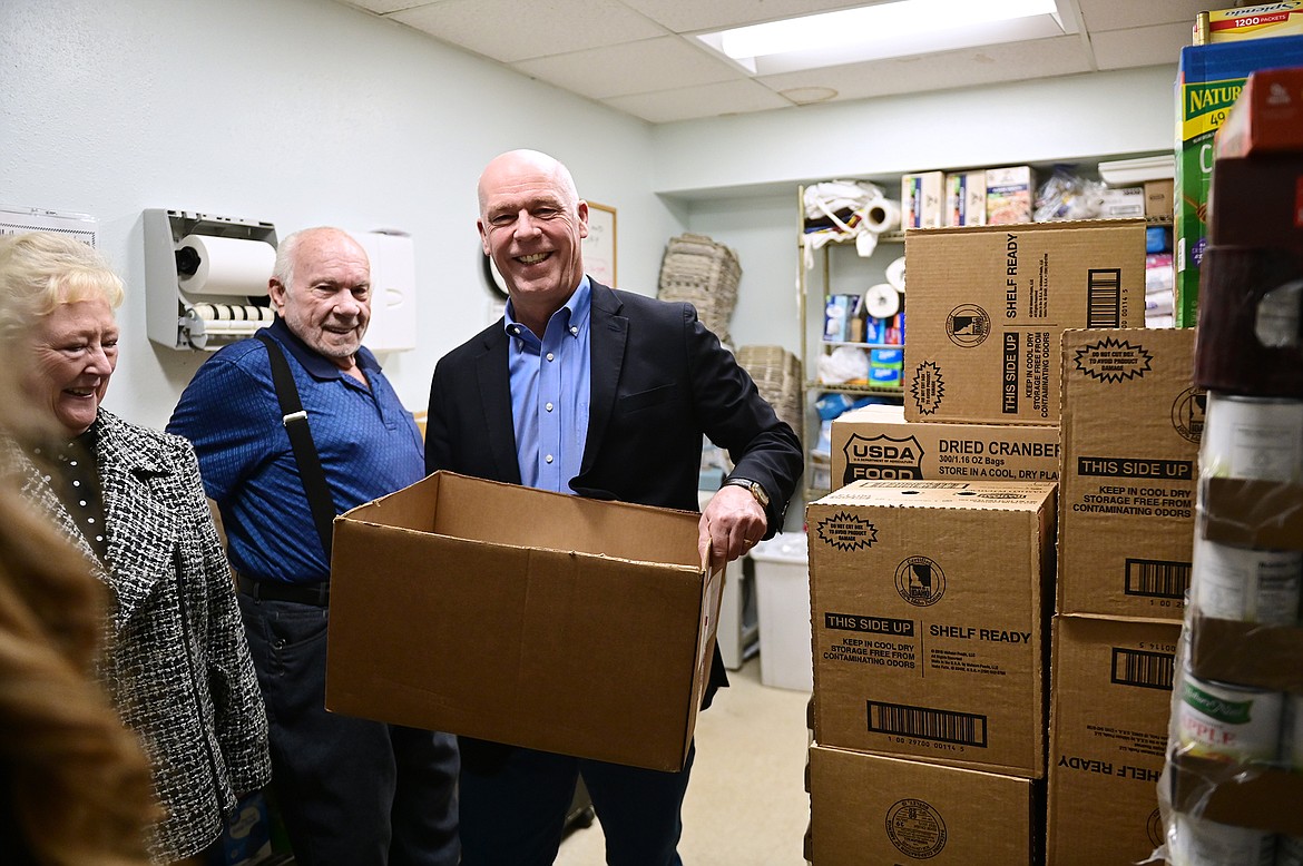 Gov. Greg Gianforte volunteers after touring the Northwest Montana Veterans Stand Down and Food Pantry in Evergreen as part of his 12 Days of Giving  campaign on Thursday, Dec. 16. (Casey Kreider/Daily Inter Lake)