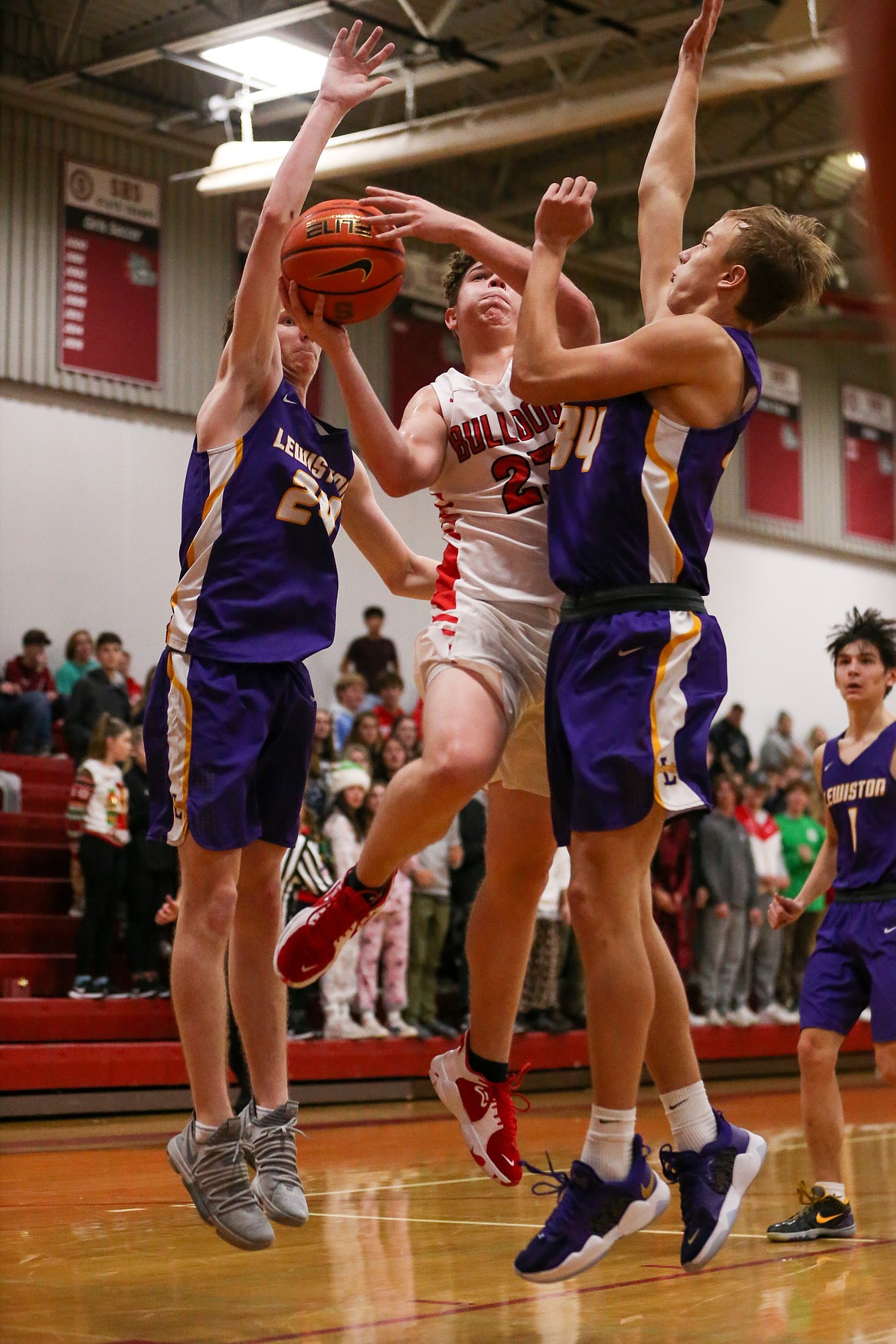 Sophomore Parker Childs splits a pair of Lewiston defenders and makes a circus layup Thursday.