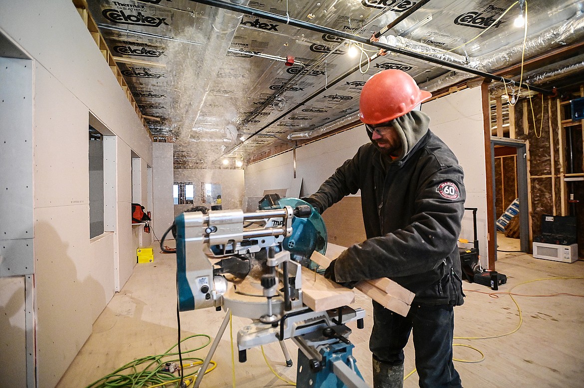 Aaron Eystad, with Martel Construction, saws boards for beams that will be outside the future offices in the county's North Campus Building in Kalispell on Thursday, Dec. 16. (Casey Kreider/Daily Inter Lake)