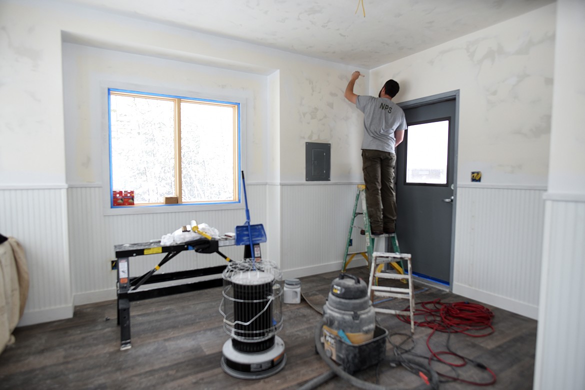 Eric Hagen paints the interior walls of the new Camas Road Entrance Station in Glacier National Park Tuesday. (Jeremy Weber/Daily Inter Lake)