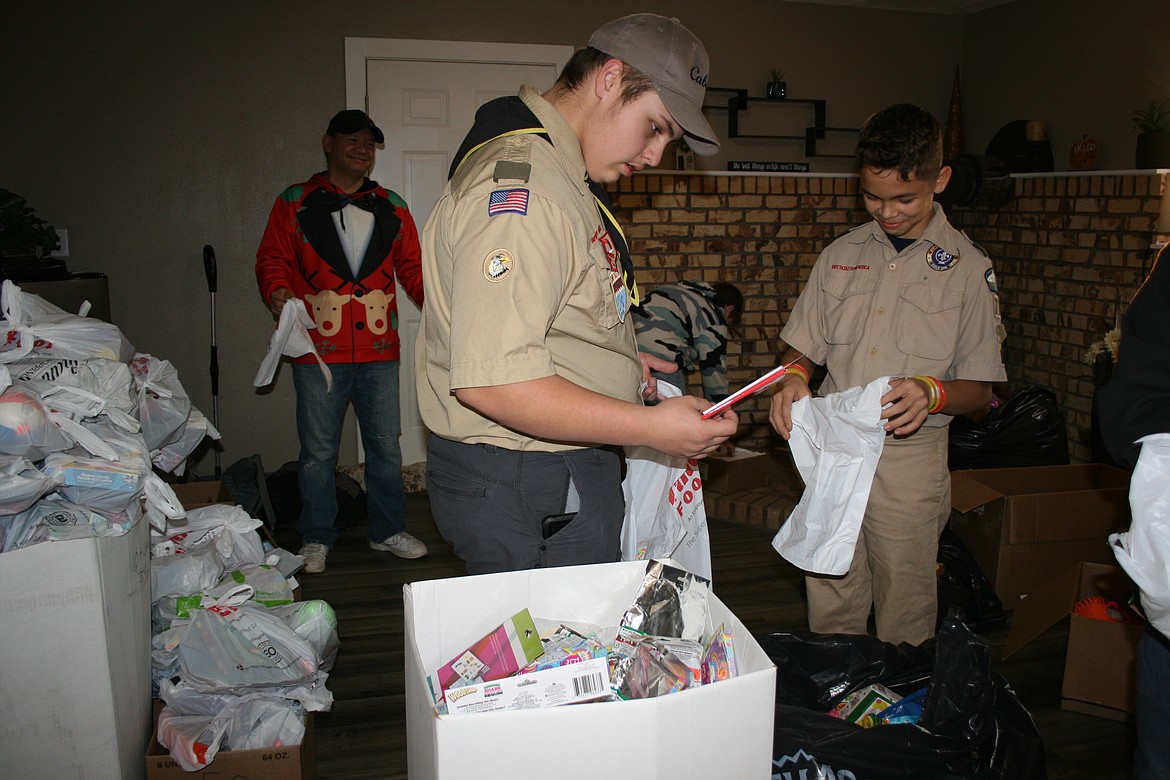 Asher Carlson, of Scout Troop 777, checks to see if it’s the right toy for the bag.