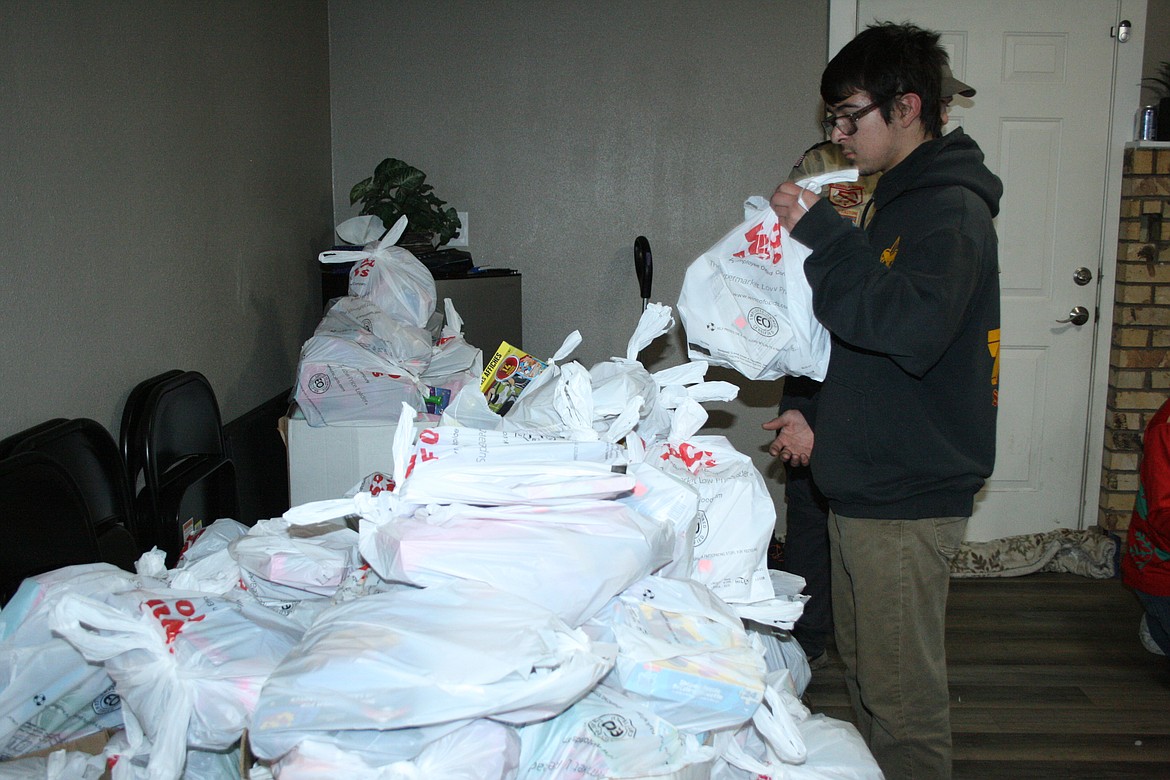Christian Williams, of Scout Troop 777, adds to the stack of sorted and bagged toys.