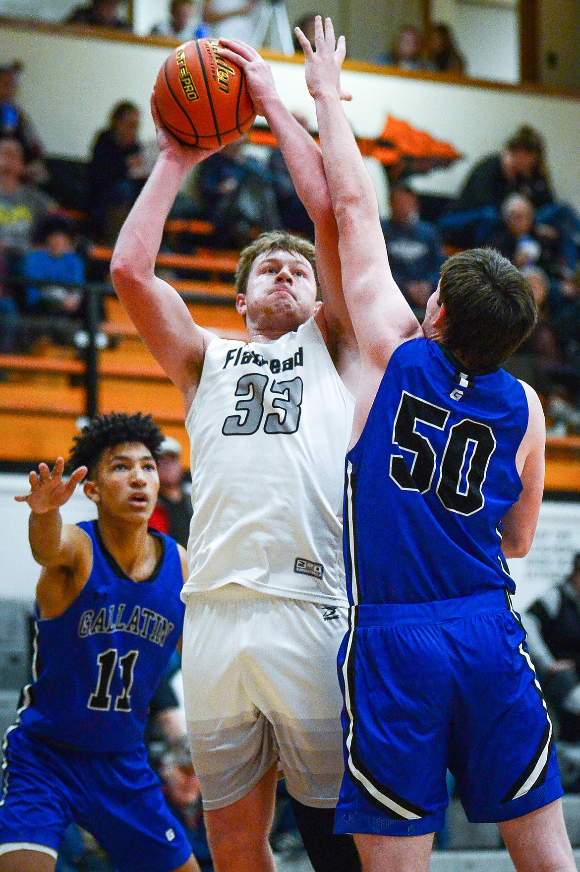 Flathead's Joe Hansen (33) looks to shoot over Gallatin's Rylan Schlepp (50) at Flathead High School on Friday, Dec. 17. (Casey Kreider/Daily Inter Lake)