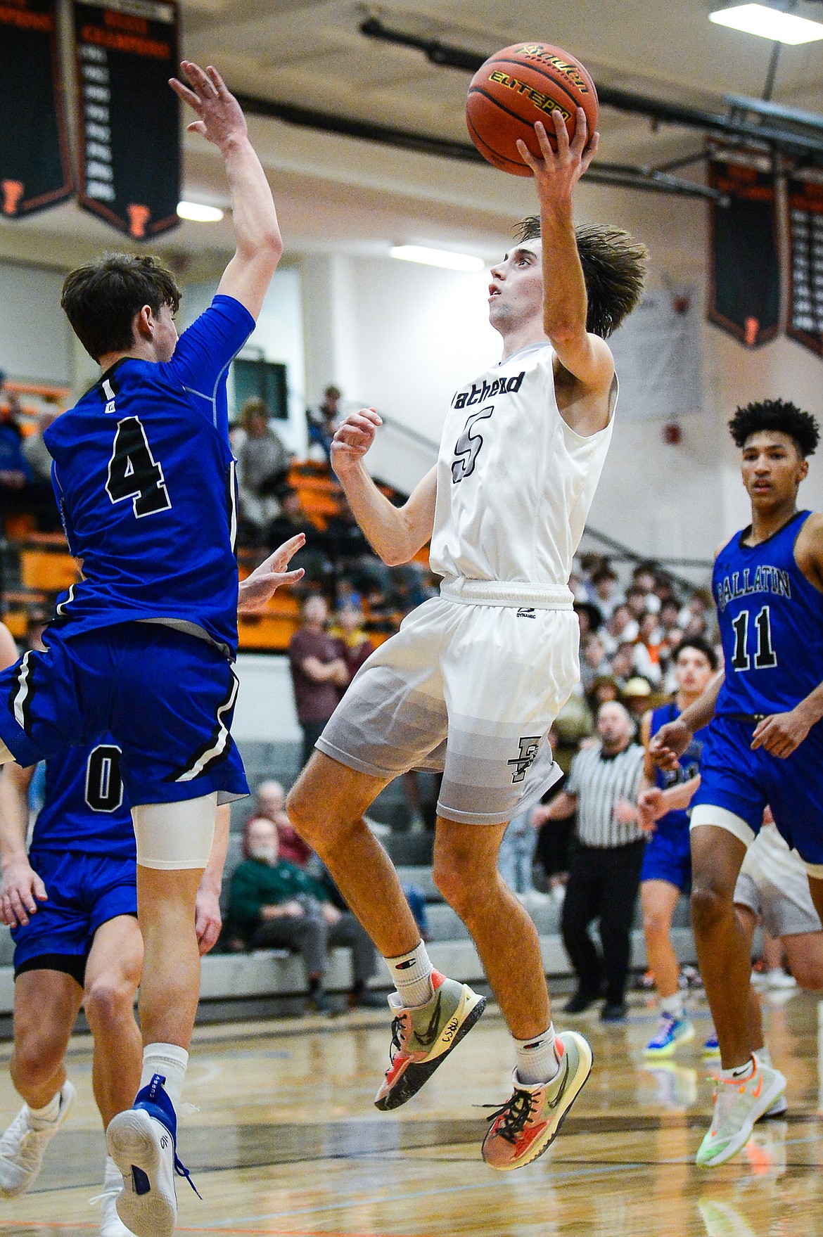 Flathead's Drew Lowry (5) drives to the basket against Gallatin's Logan Springer (4) in the first half at Flathead High School on Friday, Dec. 17. (Casey Kreider/Daily Inter Lake)