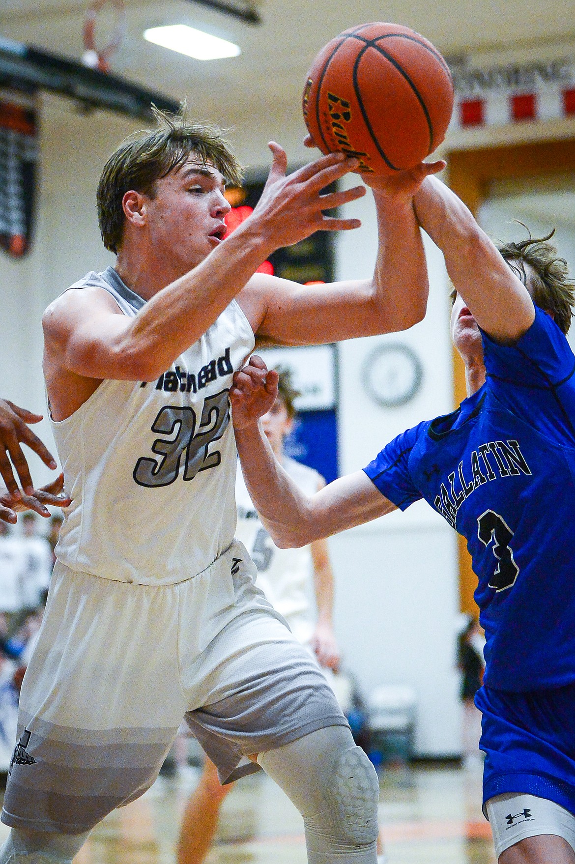 Flathead's Luca Zoeller (32) grabs a rebound against Gallatin's Eli Hunter (3) in the first half at Flathead High School on Friday, Dec. 17. (Casey Kreider/Daily Inter Lake)