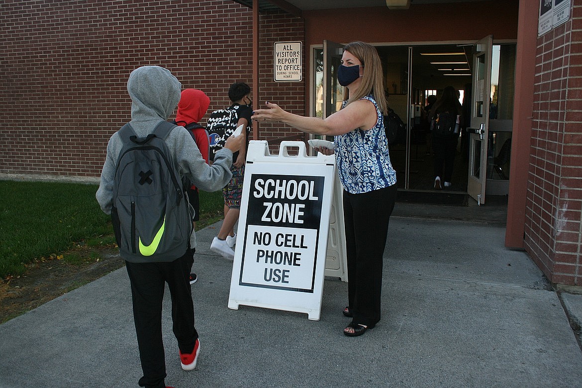 Former Frontier Middle School Principal Guinevere Joyce hands a mask to a student on Sept. 1. Joyce has been replaced at the school by new principal, John Farley. Joyce is now principal at Farley’s old campus, Midway Elementary School.