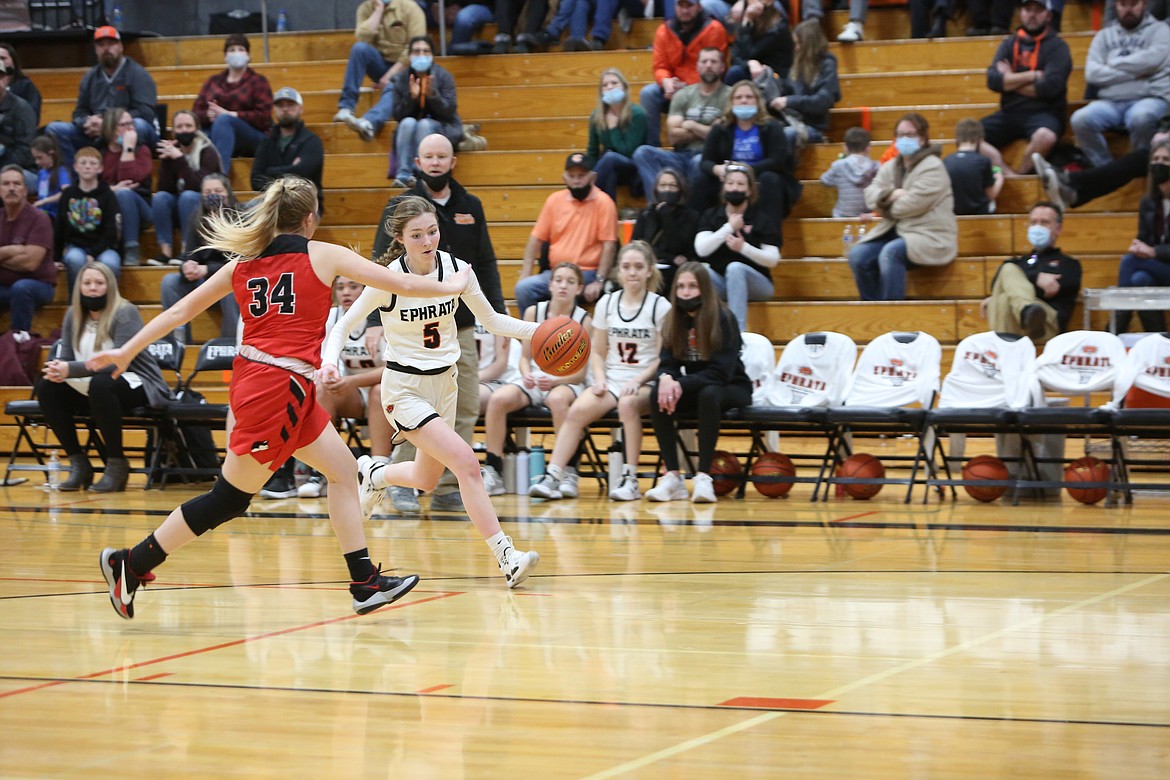 Ephrata High School sophomore Laney Hagy (5) drives the ball down court as Othello High School sophomore Riley Farman (34) tries to stay ahead of her during the Friday league matchup.