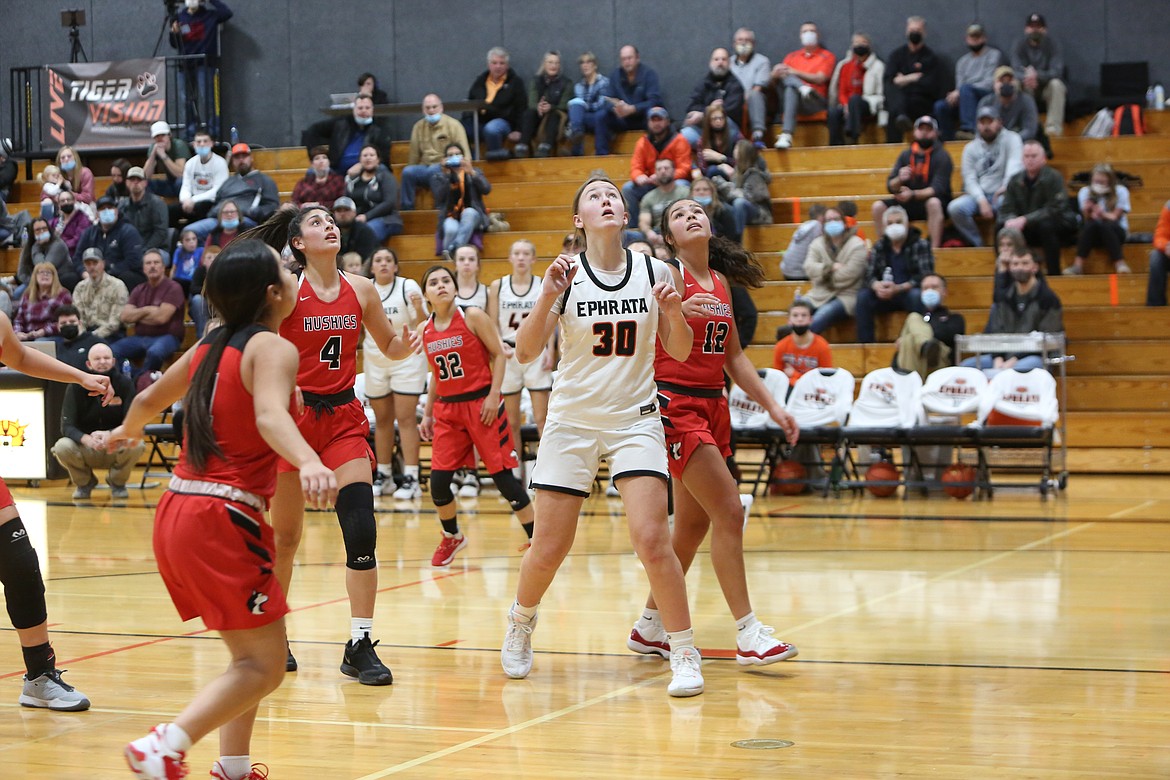 Ephrata High School sophomore Addison Mills (30) prepares to rebound the ball as Othello High School players appear to do the same.