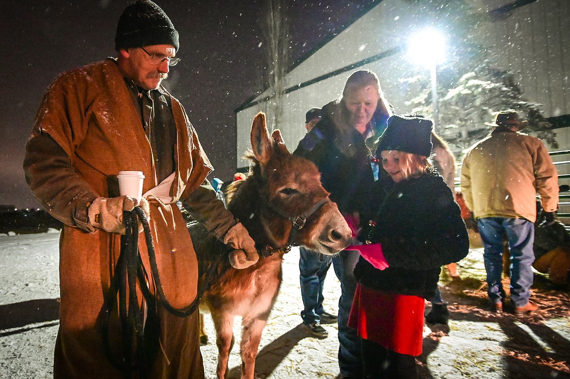 Bullseye the donkey nibbles on a young girl's glove at the live nativity at Family Life Christian Church on Saturday, Dec. 18. (Casey Kreider/Daily Inter Lake)