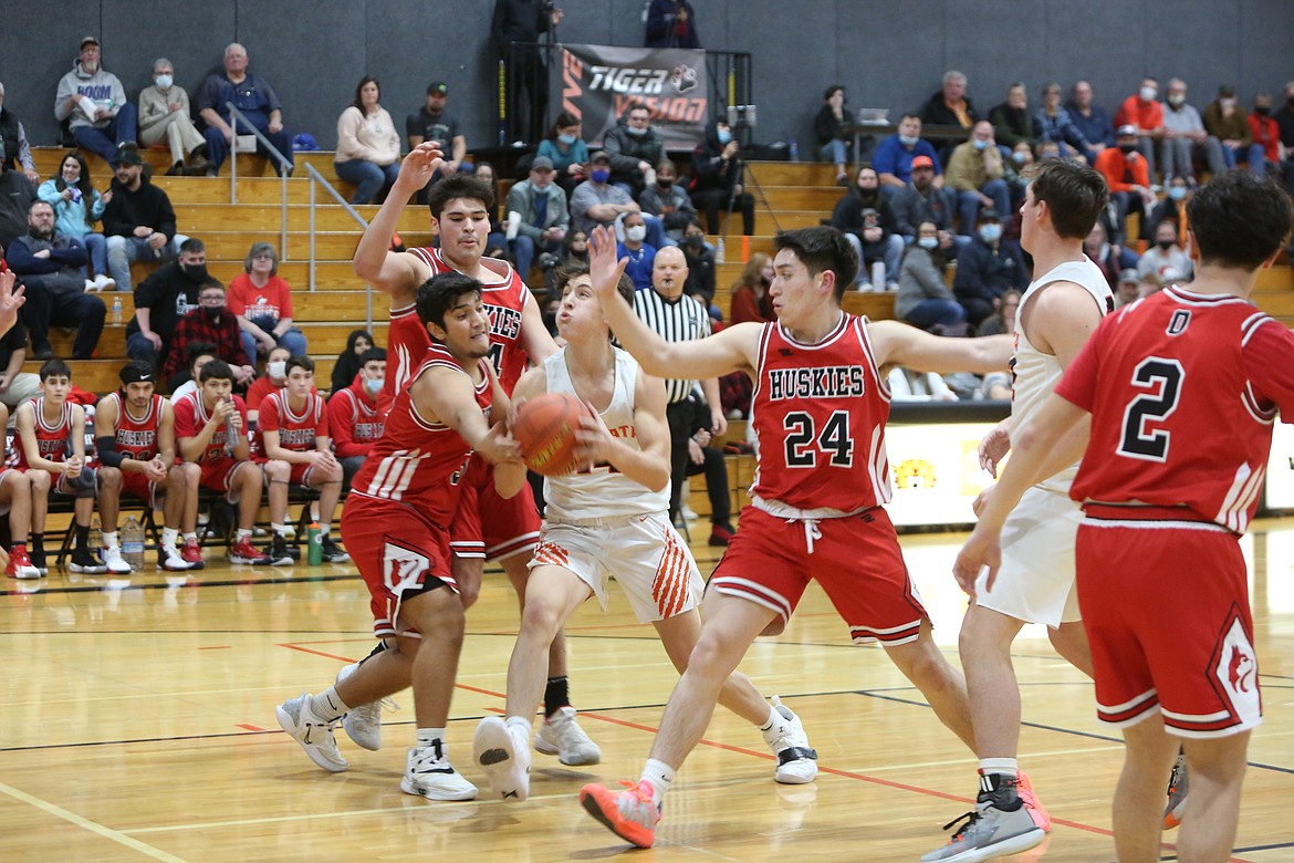 Ephrata High School sophomore Hans Roberts (14) drives to the hoop for a shot as several Othello High School players attempt to stop him.