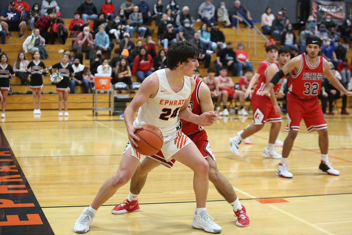 In the league matchup against Othello High School Friday, Ephrata High School senior Ethan Black (24) pivots as he decides his next move while an Othello opponent stands between him and the hoop.