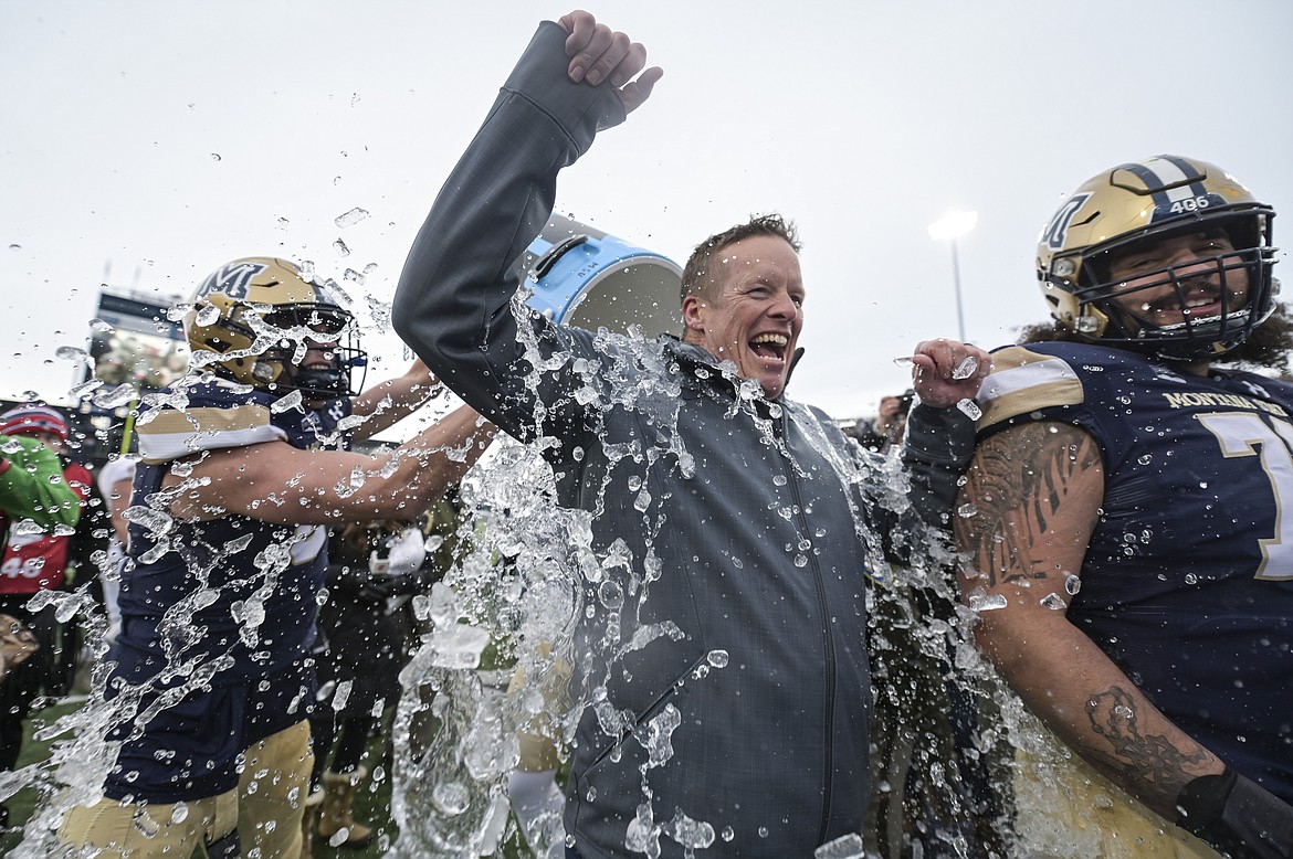 Montana State head coach Brent Vigen gets a cooler of water dumped on him after an NCAA college football game in the semifinals of the FCS playoffs, Saturday, Dec. 18, 2021, in Bozeman, Mont. Montana State beat South Dakota State 31-17. (AP Photo/Tommy Martino)