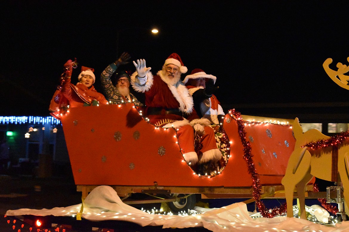 Santa, Mrs. Claus and their two elves wave from their sleigh pulled by Grant County Fire District 3 Tuesday through Quincy.