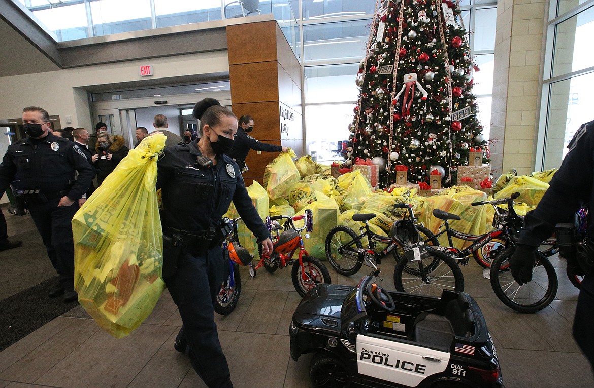 Coeur d'Alene Police Patrol Officer Kristin Finnigan carries a sack of toys into Kootenai Health on Monday. The toys will fill Andrea's Closet, a program to provide prizes and goodies for pediatric patients during their stays in the hospital.