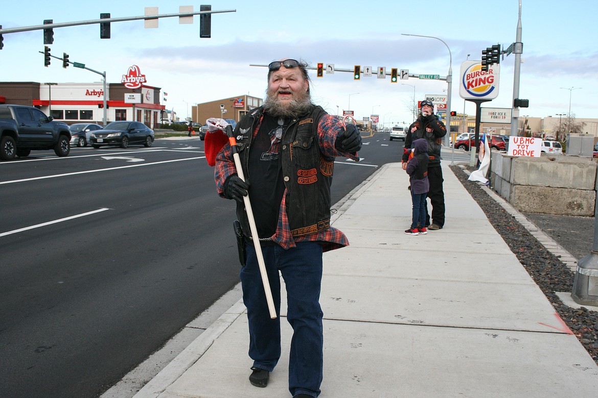 Unchained Brotherhood MC founder Jack Watrous, also known as Papa Jack, hands out a candy cane Dec. 11 during the club’s fundraiser for the Moses Lake Food Bank toy distribution.