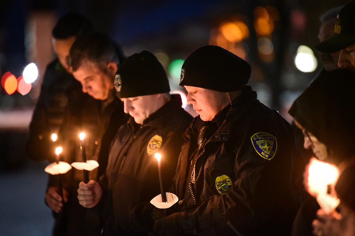 Law enforcement personnel hold candles  during the Homeless Persons' Memorial Service at Depot Park on Tuesday, Dec. 21. Hosted by the Flathead Warming Center, the service was in memory of those who have died due to a lack of housing. (Casey Kreider/Daily Inter Lake)