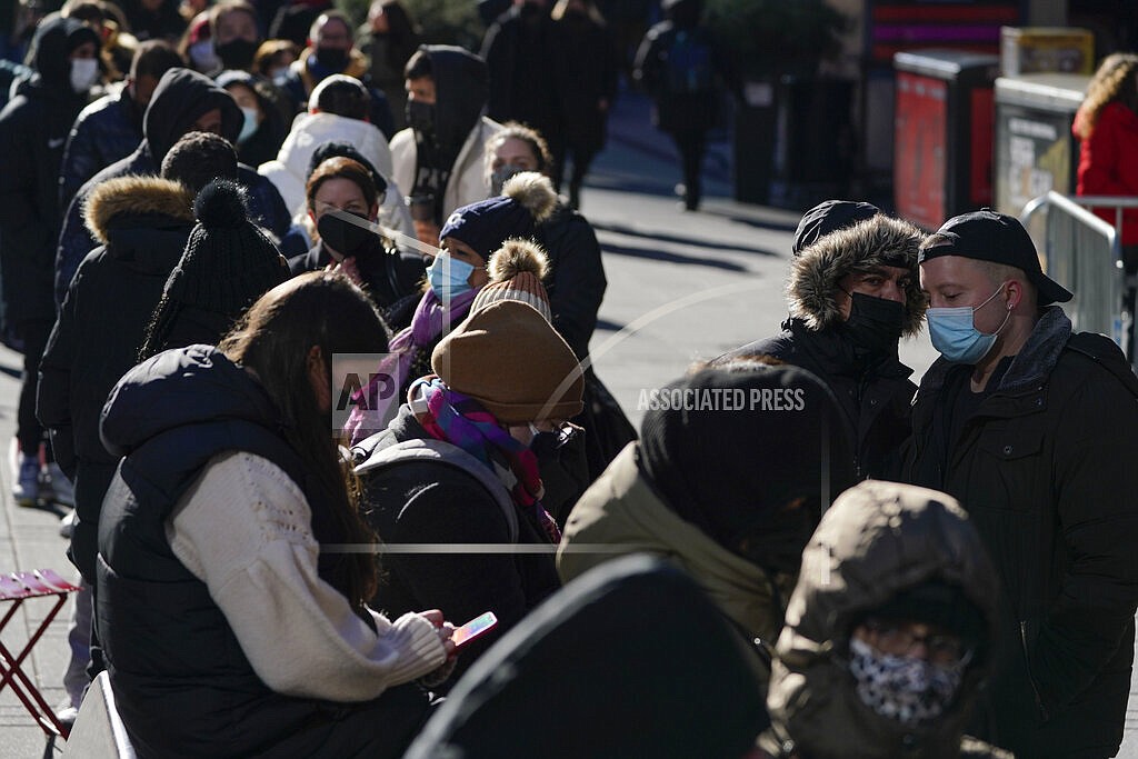 People wait in a long line to get tested for COVID-19 in Times Square, New York, Monday, Dec. 20, 2021. Just a couple of weeks ago, New York City seemed like a relative bright spot in the U.S. coronavirus struggle. Now it's a hot spot, confronting a dizzying spike in cases, a scramble for testing, a quandary over a major event and an exhausting sense of déjà vu. (AP Photo/Seth Wenig)