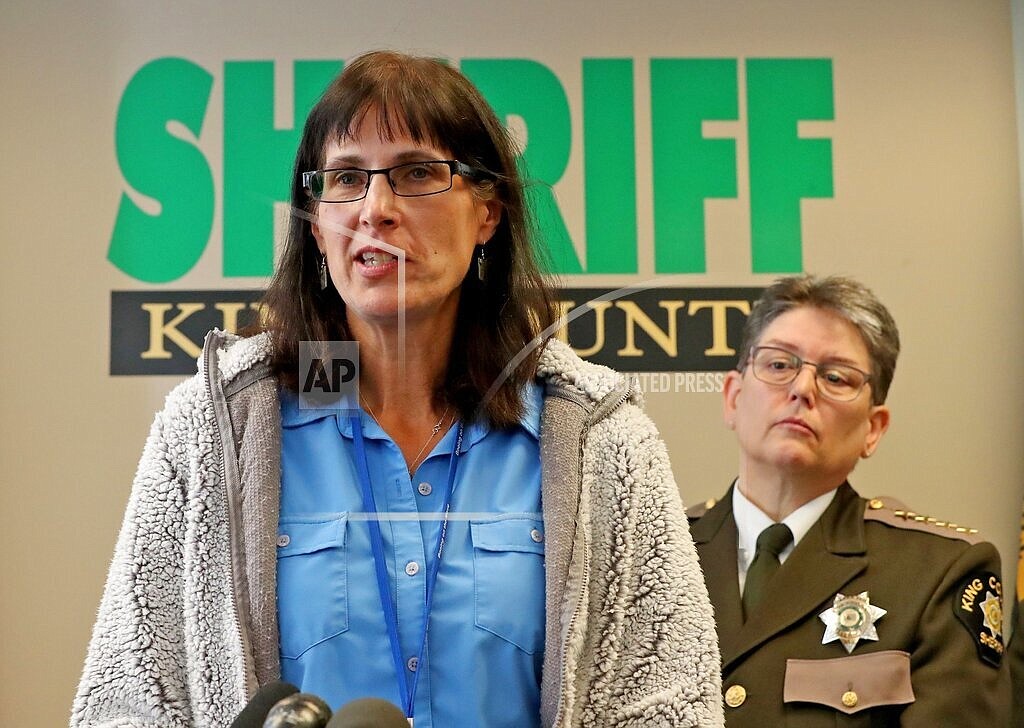 In this 2019 photo, King County Detective Kathleen Decker speaks at a news conference, while Sheriff Mitzi G. Johanknecht looks on, at right, in Seattle. Decker, a now-retired 33-year veteran of the King County Sheriff's Office, made several false statements under oath when she obtained a search warrant in a murder case in 2019, resulting in a man’s false arrest on drug charges, newly unsealed federal court orders show. (Greg Gilbert/The Seattle Times via AP)