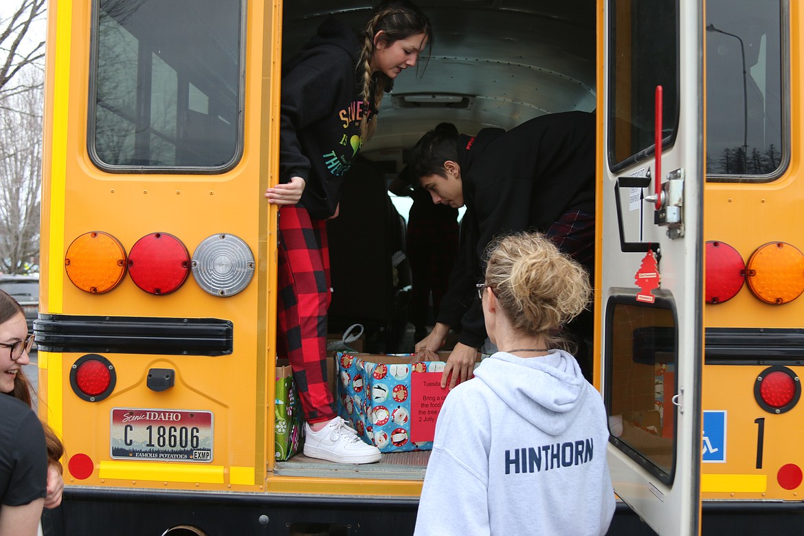 BCMS leadership students along with Kelly Hinthorn load a school bus with food drive donations.