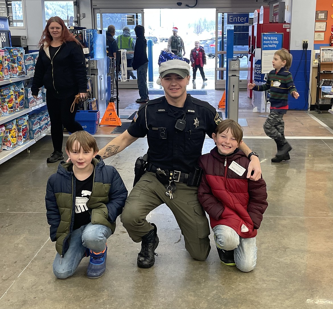 Officer Nathan Shultz alongside Trent Mellen (left) and Bready Mellen (right).