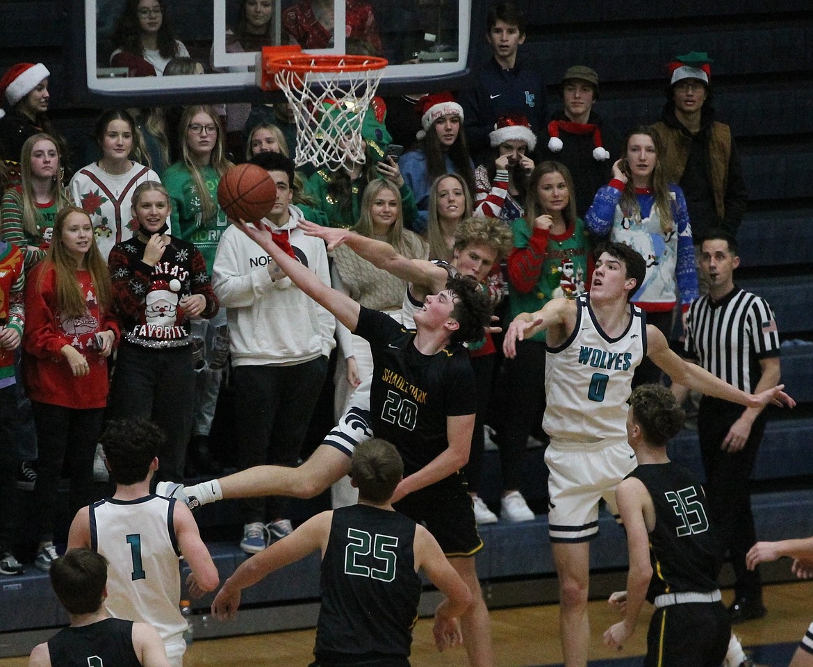 MARK NELKE/Press
Nathan Hocking, rear, and Blake Buchanan (0) of Lake City contest a shot by Kohlby Sorweide (20) of Shadle Park on Tuesday night at Lake City.