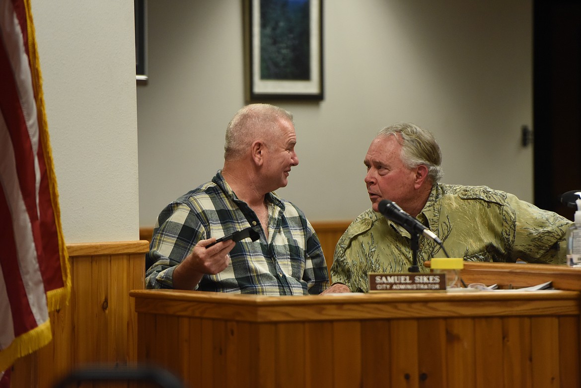 Outgoing City Councilor Rob Dufficy, right, speaks with City Administrator Samuel Sikes at a Dec. 20 Libby City Council meeting. (Derrick Perkins/The Western News)