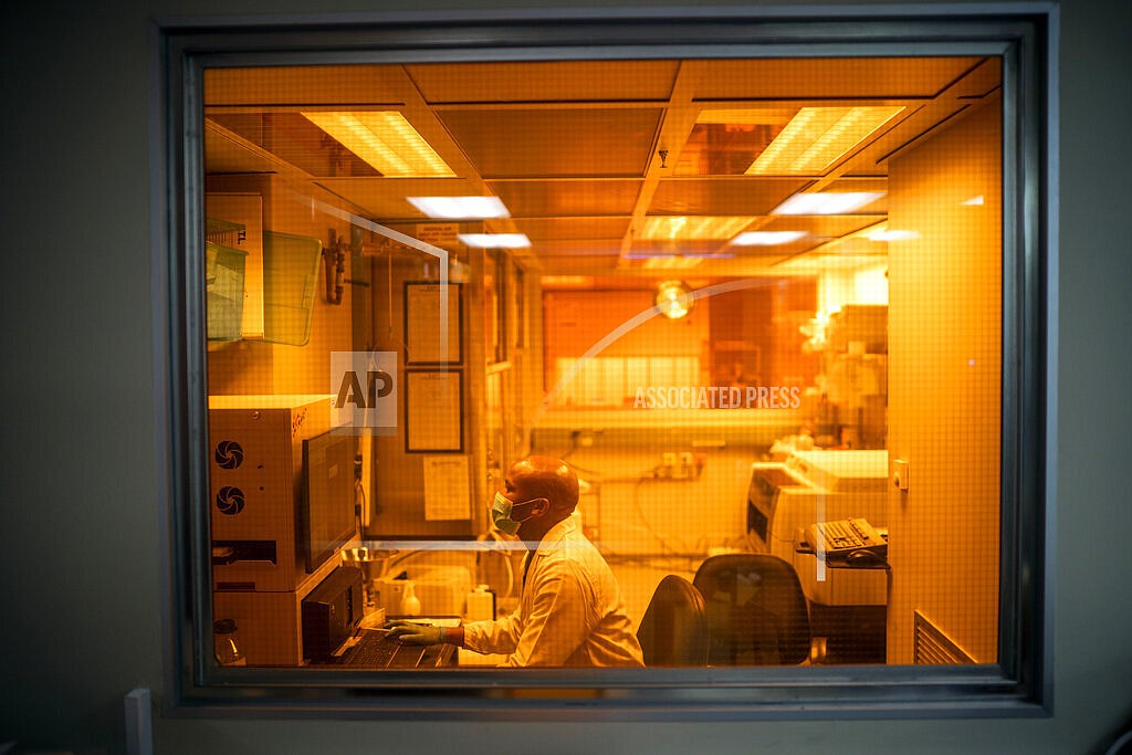 Sandile Cele, a researcher at the Africa Health Research Institute in Durban, South Africa, works on the omicron variant of the COVID-19 virus Wednesday Dec. 15, 2021. South Africa's noticeable drop in new COVID-19 cases in recent days may signal that the country's dramatic omicron-driven wave has passed its peak, medical experts say. (AP Photo/Jerome Delay, File)