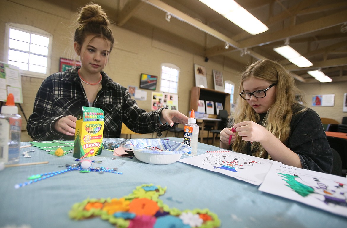 Baylee Reed, 13, left, and Lainey Tyler, 11, enjoy holiday crafts at the Human Rights Education Institute on Wednesday during a Drop n' Shop Holidays around the World activity day. The activities continue from 11 a.m. to 4 p.m. today.