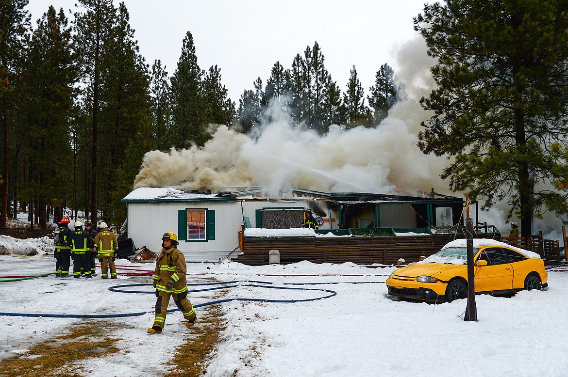 Firefighters battle a house fire along Tall Pine Ridge in West Valley on Thursday, Dec. 23. Fire crews from South Kalispell, West Valley and Smith Valley were on scene as well as the Flathead County Sheriff's and Flathead Electric. (Casey Kreider/Daily Inter Lake)