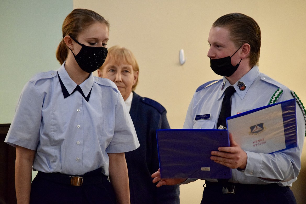 Civil Air Patrol Cadet Chief Master Sgt. Morghan Box, right, presents newly sworn-in Cadet Meghan Henke with the notebook she will use to keep track of lessons during her time as a cadet.