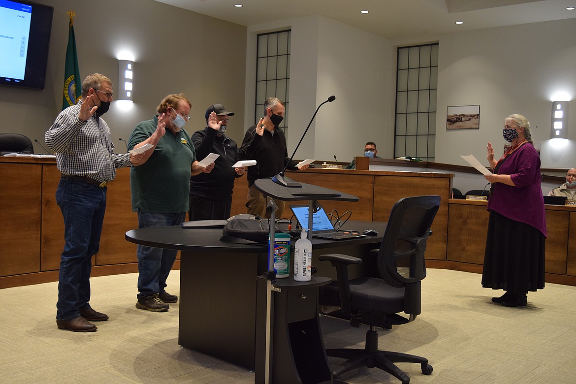 Quincy City Clerk Nancy Schanze, right, administers the oath of office to, left to right, newly elected city council member Dave Dormier, Mayor Paul Worley, newly elected council member Jeff Spence and returning council member Andrew Royer.