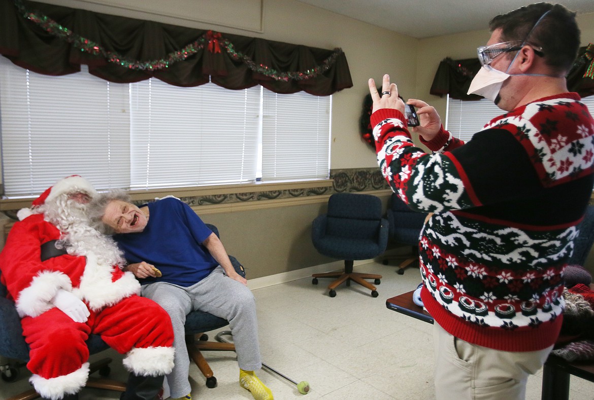 Lacrosse Health and Rehabilitation executive director Tyson Taylor snaps a picture of Santa with resident Arthur Hutchison on Thursday.