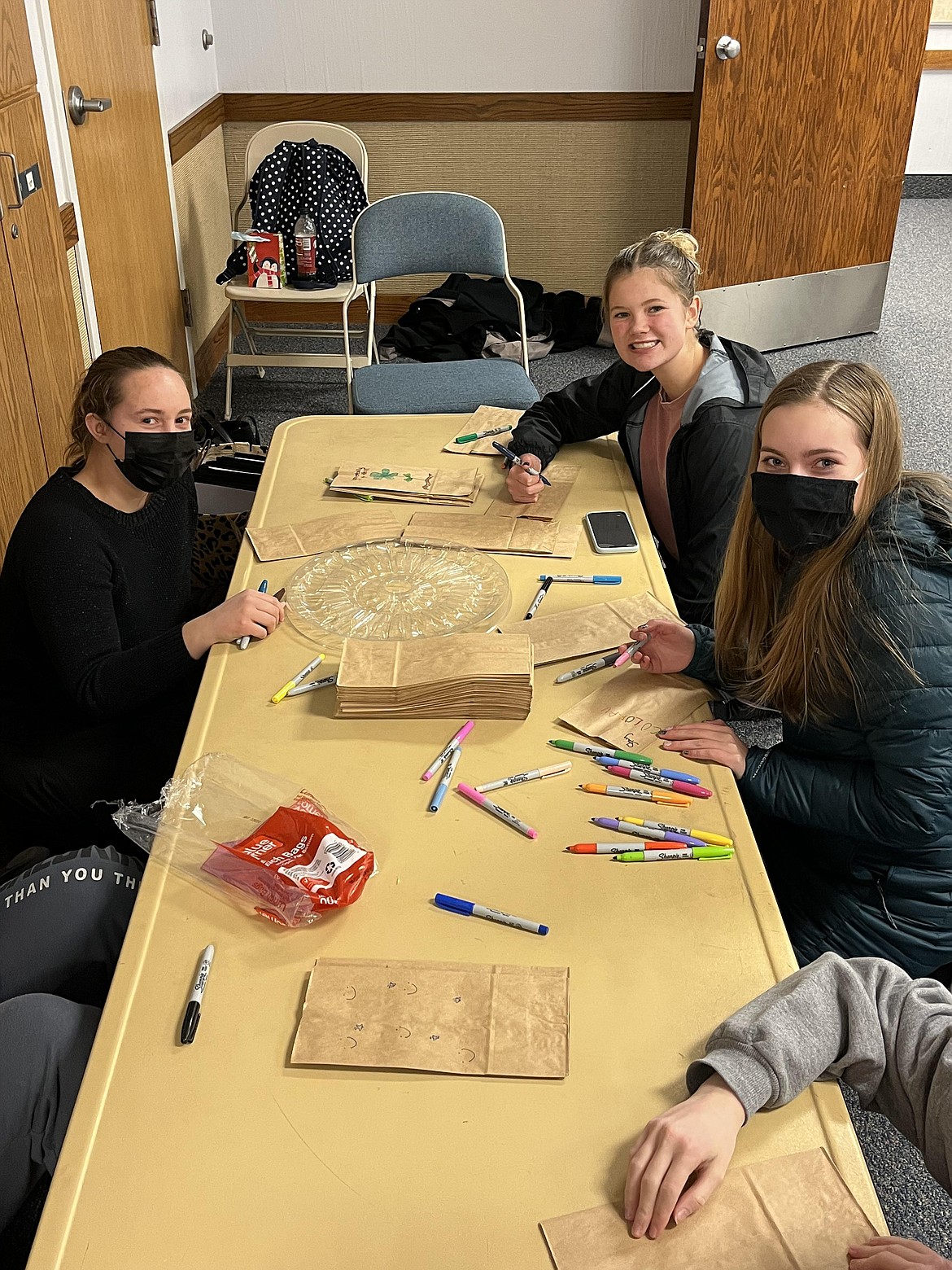 From left, Audrey Donaldson, Julia Heaps and Miriam Fife assemble snack bags for New Hope and Child Protective Services.