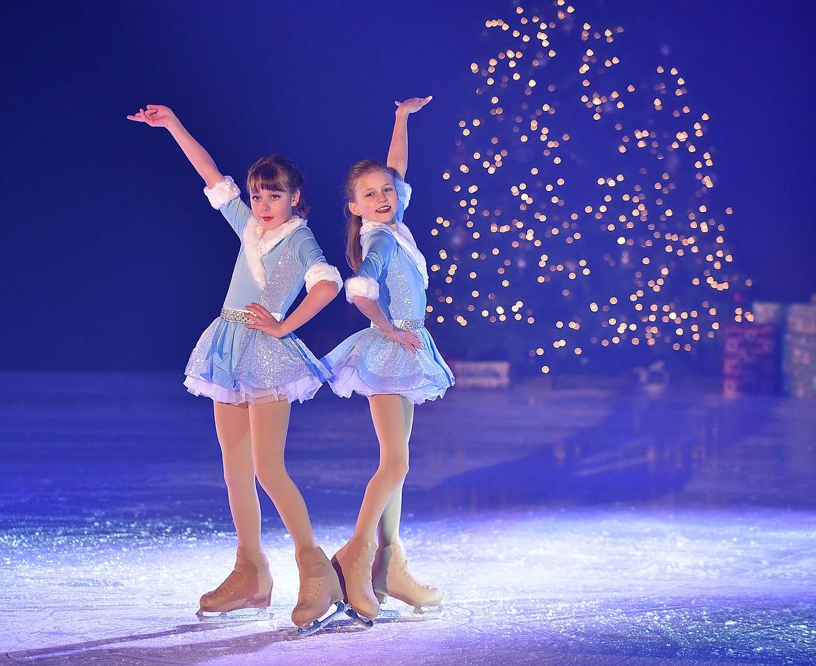 Kensington Blystone and Lexi Davis smile for the crowd after their performance during the Glacier Skate Academy’s recent Christmas on Ice show. (Heidi Desch/Whitefish Pilot)