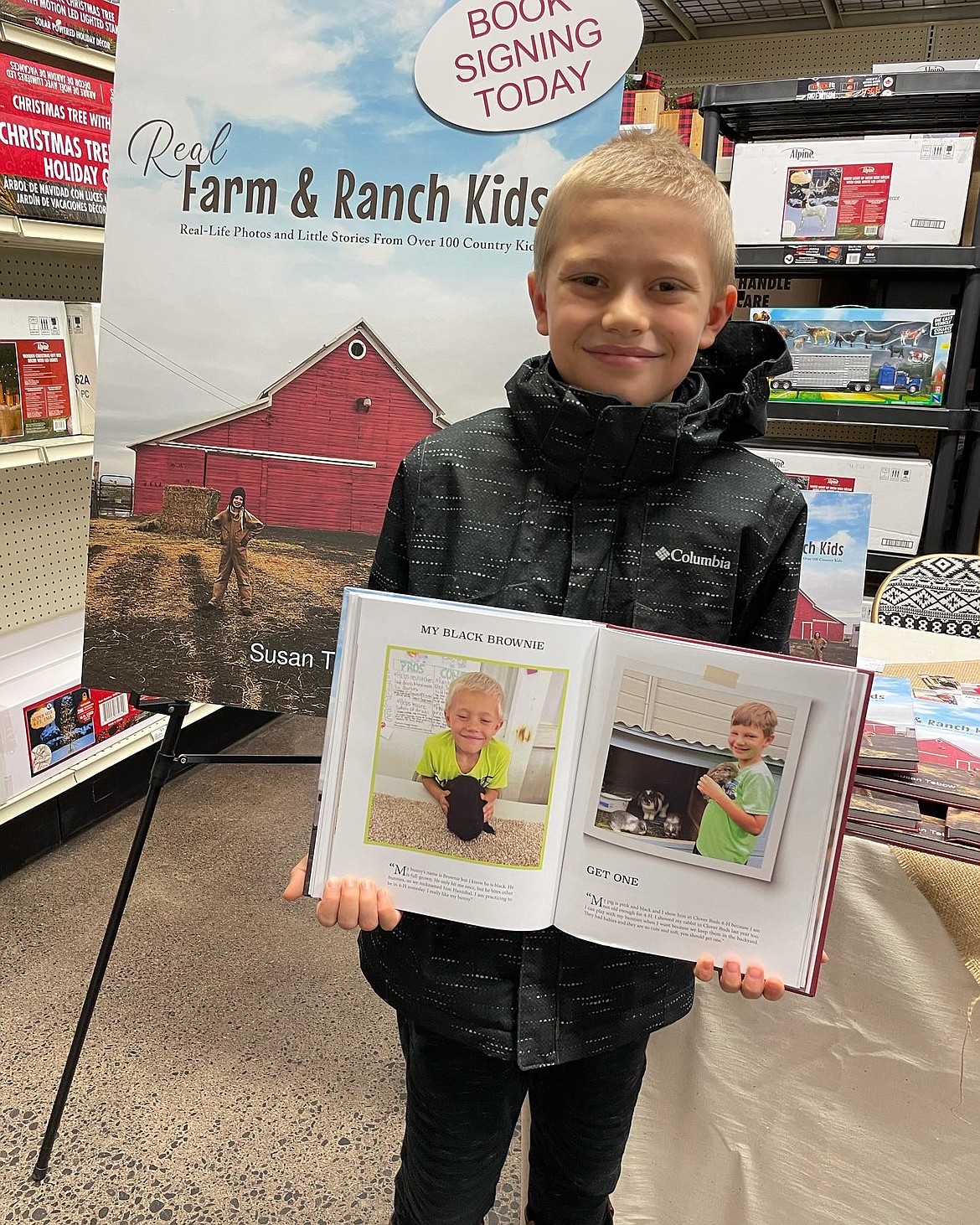 A subject in Sue Tebow’s new book “Real Farm and Ranch Kids” proudly displays his picture. Tebow does not release the names of her subjects.