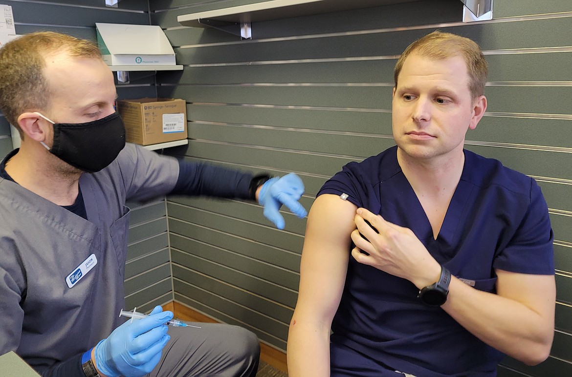 Pharmacists Jason Head, left, and Korey Kreider demonstrate a flu shot administration Monday at Medicine Man Prairie Pharmacy. The Idaho Department of Health and Welfare announced a Gooding County man older than 65 has been reported as Idaho's first flu death of the 2021-2022 flu season.