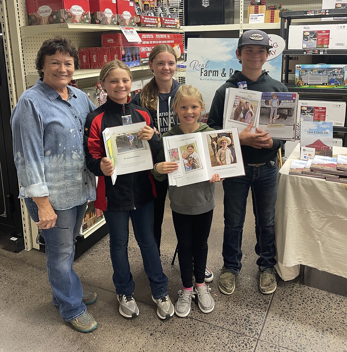 Sue Tebow (left) and four of the subjects from her book, “Real Farm and Ranch Kids” at a book signing in November. Tebow does not give out the names of her subjects.