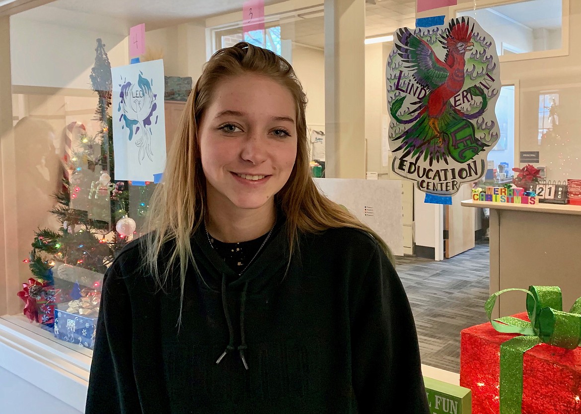 Kenzye Fishel stands next to her winning mascot design at Linderman Education Center Tuesday, Dec. 21, 2021. Linderman chose the mythical phoenix as a school mascot and asked students to submit and vote on designs. (Hilary Matheson/Daily Inter Lake)