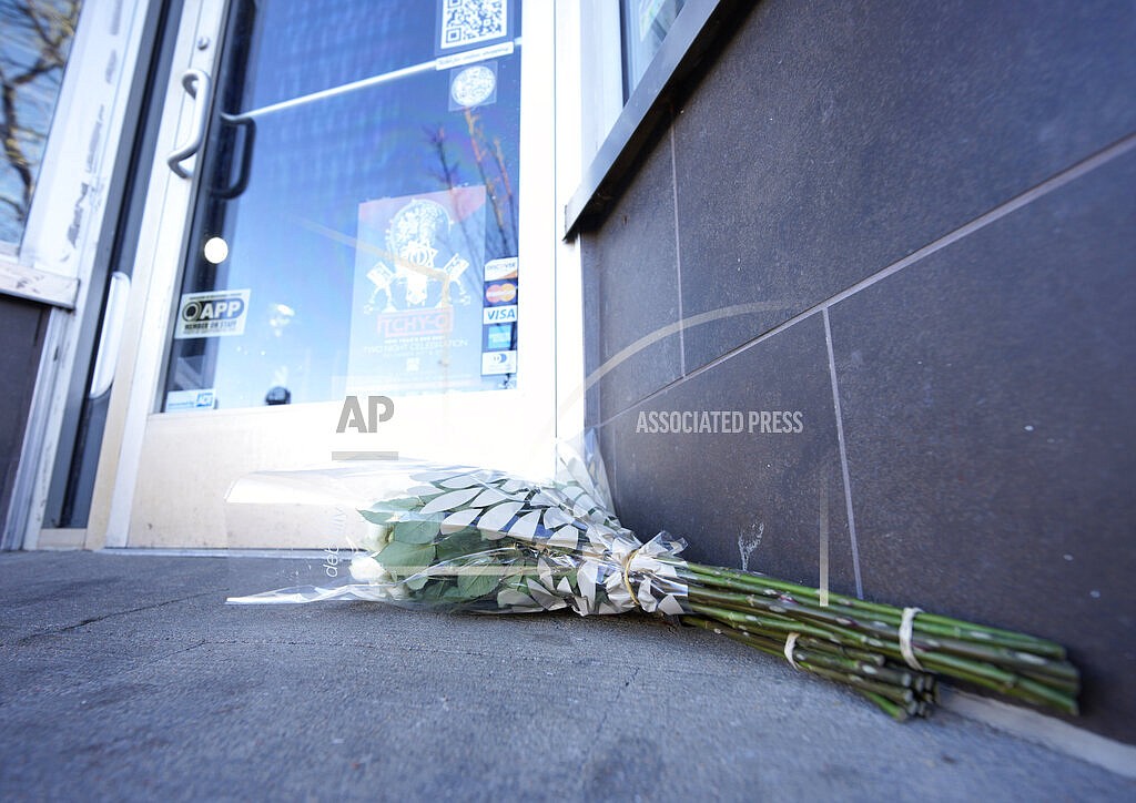 Bouquets of flowers are placed outside the door of a tattoo parlor along South Broadway Tuesday, Dec. 28, 2021 in Denver, one of the scenes of a shooting spree that left five people dead—including the suspected shooter Monday evening—and left a few more people wounded. The spree spread from the core of Denver to the western suburb of Lakewood where the suspect was shot and killed by police near a busy intersection in a bustling shopping district. (AP Photo/David Zalubowski)