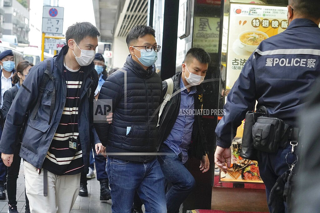 Editor of "Stand News" Patrick Lam, second from left, is arrested by police officers in Hong Kong, Wednesday, Dec. 29, 2021. Hong Kong police say they have arrested seveal current and former staff members of the online media company for conspiracy to publish a seditious publication. (AP Photo/Vincent Yu)