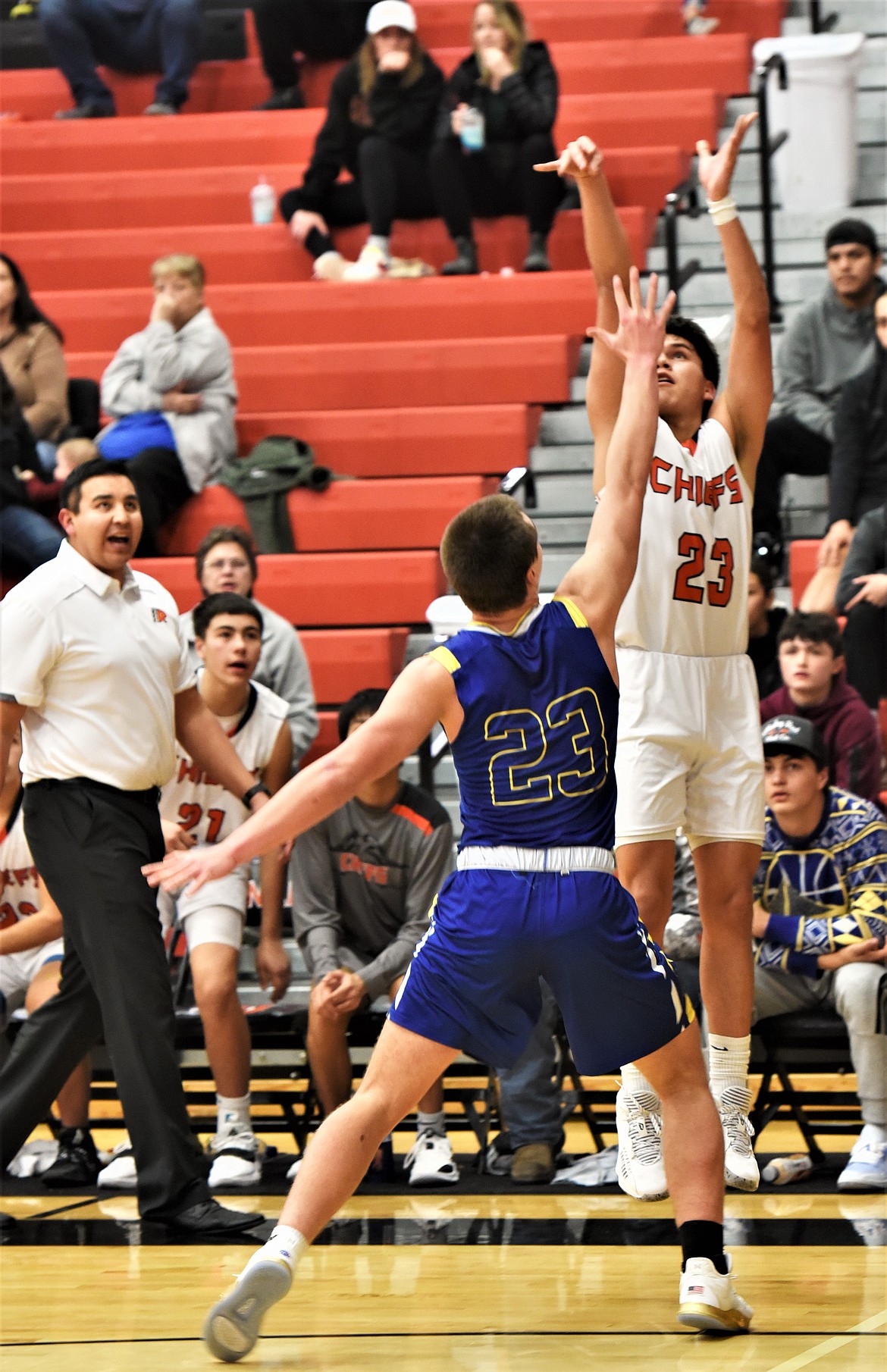 Elijah Tonasket puts up a 3-pointer against Libby in front of Ronan head coach DJ Fish. (Scot Heisel/Lake County Leader)