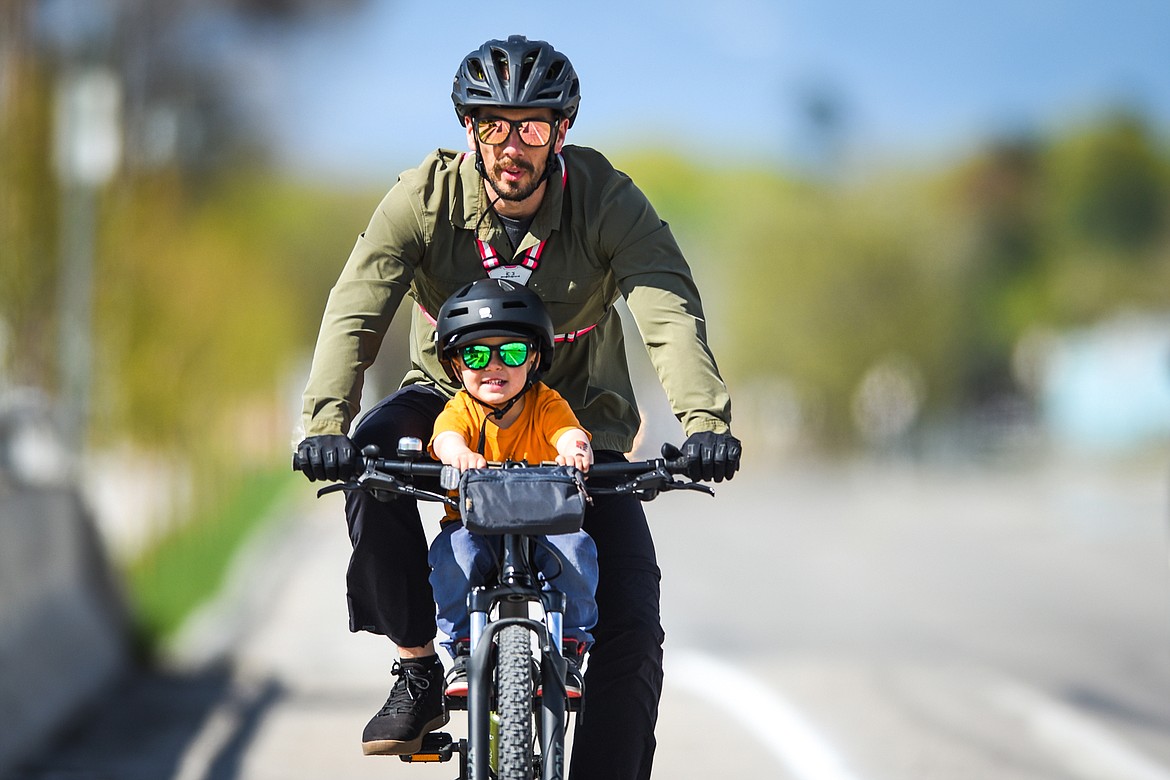 Seamus Burke and his son Cillian, 3, of Kalispell, go for a bike ride along Airport Road on Thursday, May 13. (Casey Kreider/Daily Inter Lake)