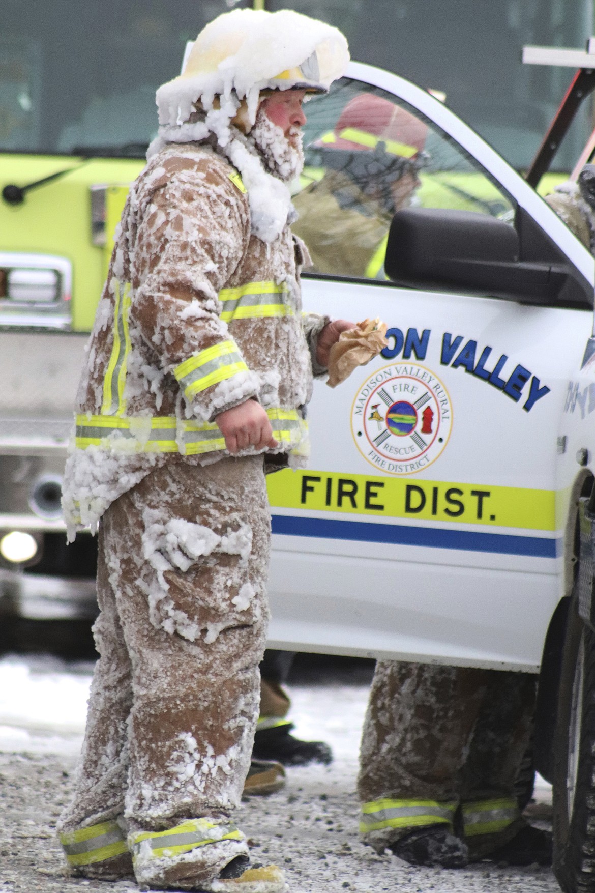 Firefighter Pat Noack is covered in ice after fighting a fire at a four-unit apartment building in Ennis, Mont., on Wednesday, Dec. 29, 2021. Sub-zero wind chills caused fire nozzles and firefighter's breathing equipment to freeze up, said Joe Brummell, the director of Disaster and Emergency Services in Madison County in southwestern Montana. Nobody was injured, but three of the four apartments were a complete loss, Brummell said. (Jolene Palmer/The Madisonian via AP)