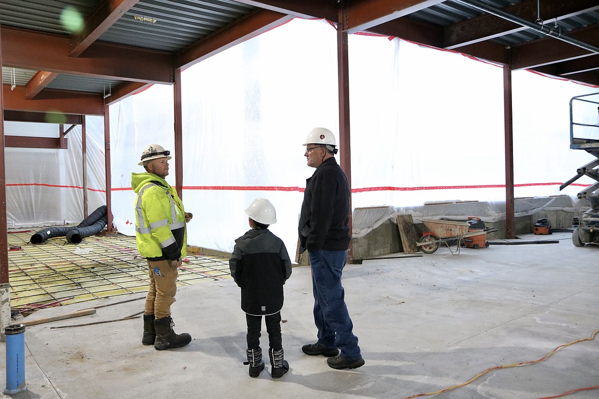 On far right, Garry Stark, director of facilities operations for NIC, accompanied by his grandson Leon, speak with construction worker Ken Sheets in the Meyer Health and Science building expansion on Dec. 29 at North Idaho College. HANNAH NEFF/Press