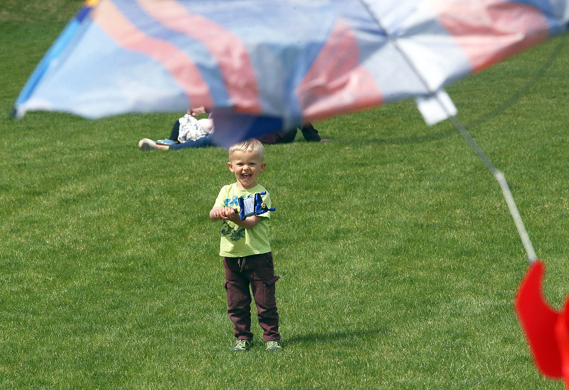 Jacob Dollahite smiles beneath a colorful kite at the 2021 Hayden Kite Festival at Broadmoore Park.